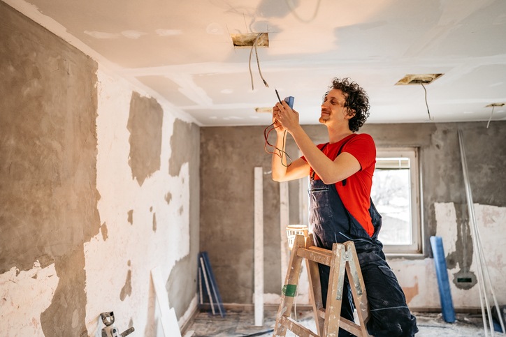 An electrician is working on house rewiring in San Jose, CA